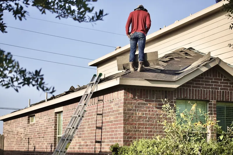 Professional roofer working on a residential roof in Alton